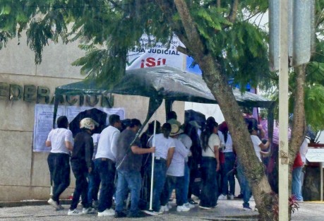 Personal del PJF cubriéndose en conjunto de la fuerte lluvia.