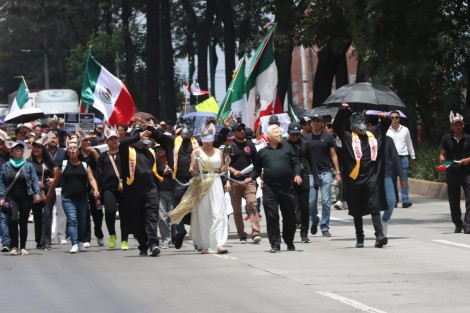  Ahora llevaron un performance con un ataúd y una mujer disfrazada de la justicia que era maltratada por un hombre con máscara de AMLO.