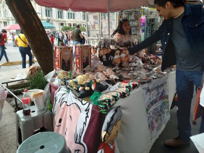 Numerosos puestos de comercio informal en la Avenida Juárez de la Ciudad de México con artículos del controversial AMLITO.  Aunque ya se introducen nuevos personajes, es incierto si alcanzarán la misma popularidad. 