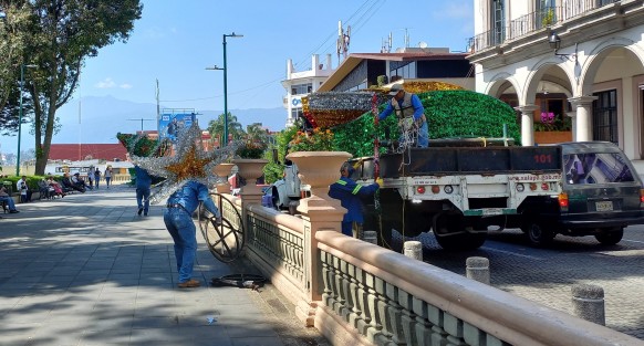 Personal del Ayuntamiento de Xalapa desempaca la decoración navideña en el parque Benito Juárez.