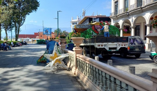 Personal del Ayuntamiento de Xalapa desempaca la decoración navideña en el parque Benito Juárez.
