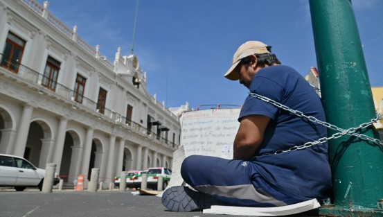 Juan Ricardo Ordóñez Jerez, oriundo de Coatzacoalcos, se encadenó este martes a un poste de luminarias en plena Plaza Lerdo, frente al Palacio de Gobierno de Veracruz. Al mismo tiempo, inició una huelga de hambre como forma de exigir protección y justicia, luego de denunciar amenazas de muerte tras haber expuesto un presunto fraude inmobiliario que involucra —según sus señalamientos— a personas cercanas a la Fiscalía General del Estado.